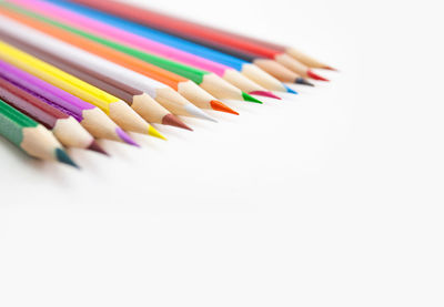 Close-up of multi colored pencils against white background