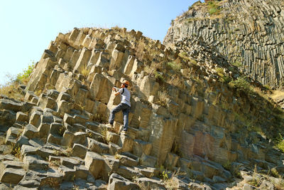 Low angle view of man climbing on rocks