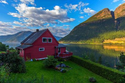 Houses by lake and buildings against sky