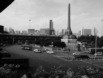 Cars on road in city against sky