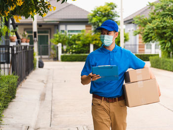 Man holding box standing outdoors