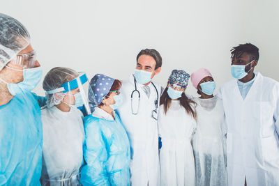 Doctors wearing mask standing against white background