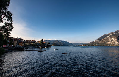 Scenic view of river by mountains against sky