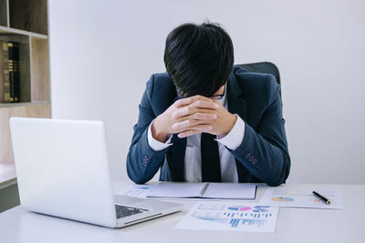 Tired businessman sitting at desk in office