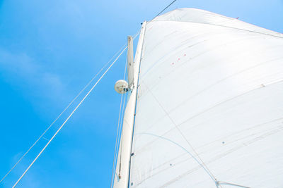 Low angle view of sailboat against blue sky