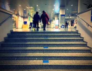 Rear view of people walking on staircase