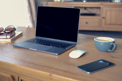 Coffee and laptop with mobile phone on table