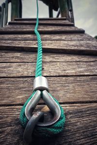 Close-up of rope tied on wooden plank