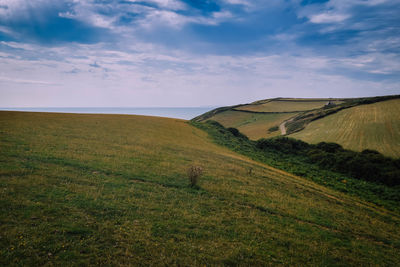 Scenic view of landscape and sea against sky