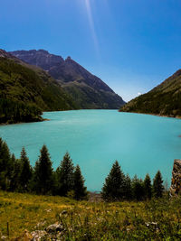 Scenic view of lake and mountains against blue sky