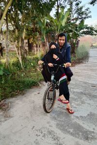 Young woman riding bicycle on footpath