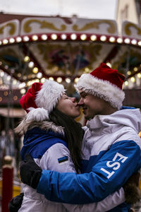 Midsection of woman with christmas lights during winter