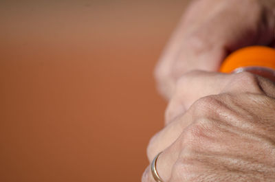 Close-up of man holding hands over white background