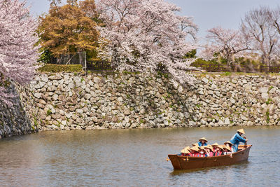 People in boat against river