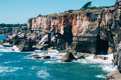 Rock formations in sea against clear sky