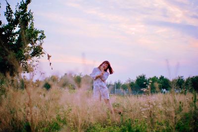 Full length of woman standing on field against sky