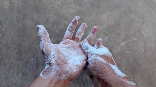 Close-up of person hand on sand