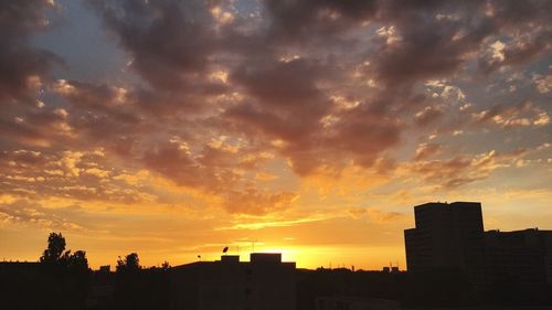 Silhouette cityscape against sky during sunset