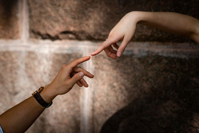 Close-up of couple hand against wall