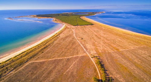 Scenic view of road by sea against sky