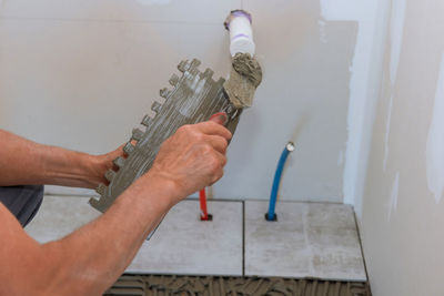 Cropped hand of man holding thermometer