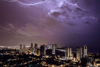 Illuminated cityscape against sky at night