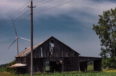 Abandoned house on field against sky