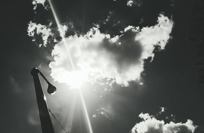 Low angle view of sun shining through clouds