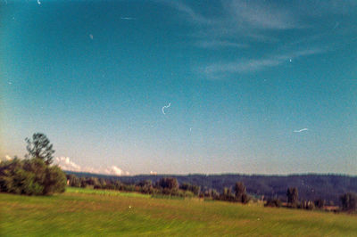 Scenic view of field against blue sky