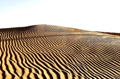 Sand dunes against clear sky