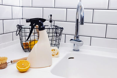 Reusable spray bottle and eco natural items for kitchen cleaning near the sink. 