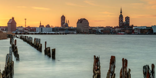 Panoramic view of sea and buildings against sky during sunset