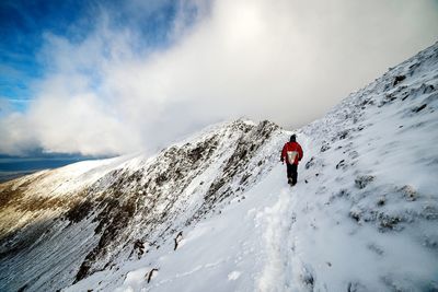 Tourists walking on snow covered landscape