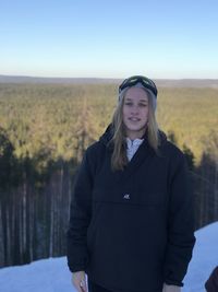 Portrait of woman standing on snow covered land