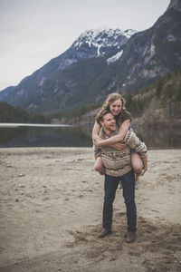 Boyfriend piggybacking girlfriend against mountains at silver lake provincial park