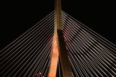 Low angle view of suspension bridge against sky at night