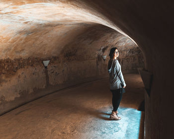 Full length of woman standing in tunnel