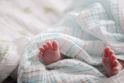 Low section of baby feet on bed