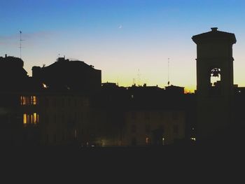 Silhouette city against sky during sunset