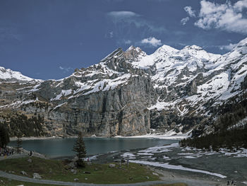 Scenic view of snowcapped mountains by lake against sky