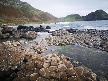 Rocks in sea against sky