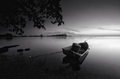 Boat moored in lake against sky