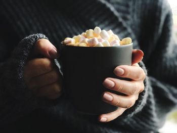 Midsection of woman having drink with marshmallows