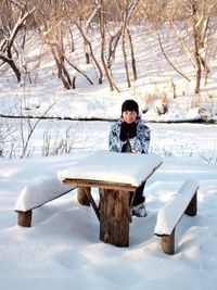 Man sitting on snow covered field