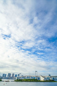 Low angle view of suspension bridge against cloudy sky