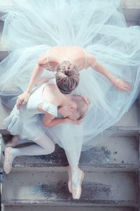 Directly above shot of ballet dancers sitting on staircase