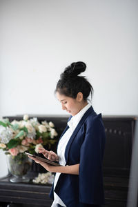 Side view of a young woman using smart phone