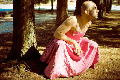 Woman sitting on tree trunk in forest