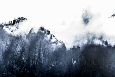 Low angle view of mountains against cloudy sky