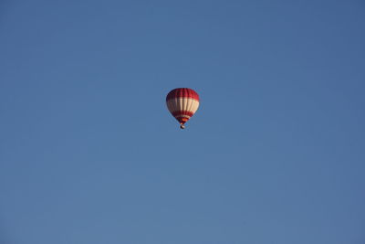 Low angle view of hot air balloon against clear blue sky